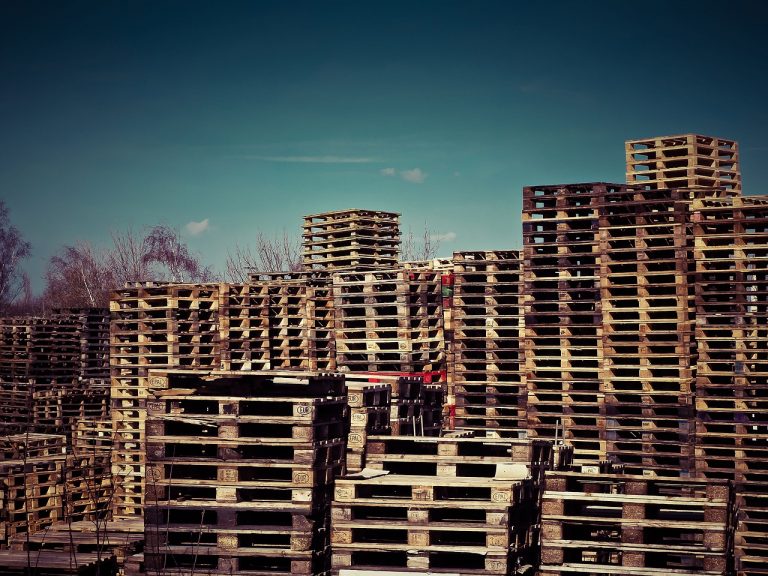 a large pile of wooden pallets in a yard